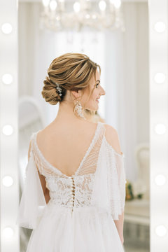 Portrait of a beautiful young bride in a bright room in a romantic atmosphere. Close-up of wedding makeup and hairstyle