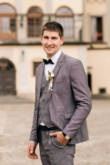 Portrait of the groom on the background of an old building