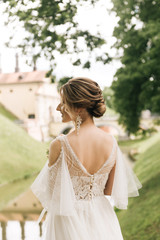 Fototapeta na wymiar Beautiful elegant bride on the background of an old castle, European wedding