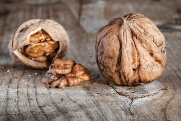 walnuts on a wooden table. Whole (in shell) and split and nut kernel.
