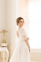Portrait of a beautiful bride next to a piano in a luxurious interior