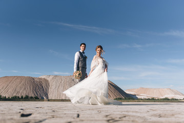 Beautiful elegant couple of newlyweds in love on a beautiful natural background of salt mountains and quarries