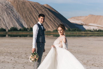 Beautiful elegant couple of newlyweds in love on a beautiful natural background of salt mountains and quarries