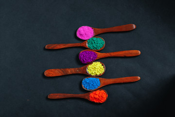 Indian Festival Holi , Colors in wooden spoon on dark background 