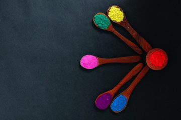 Indian Festival Holi , Colors in wooden spoon on dark background 