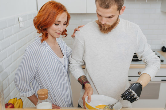 Happy married couple cooking together, whisking mixture in a bowl - Powered by Adobe