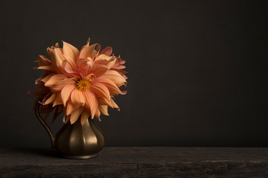 Bouquet of blooming chrysant flowers in a golden vase on a table in a classical fine art image