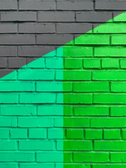 Graffiti abstract painted geometrically neon green and black textured brick wall vertical