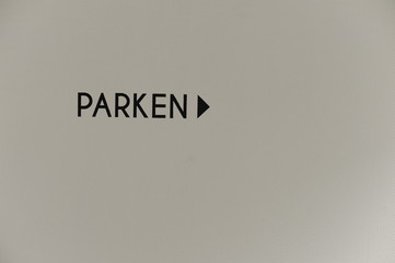 Black-white Parking sign with an arrow in German