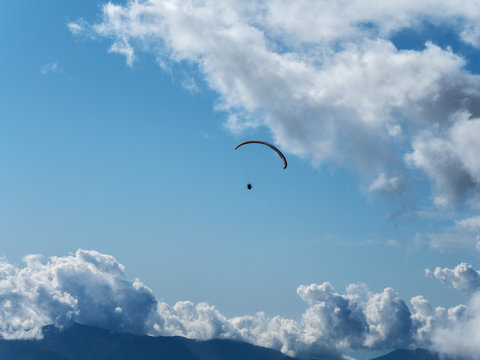 Paraglider flying far in the sky against the background of clouds