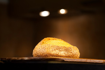 Loaf of sesame seed bread illuminated by spotlights