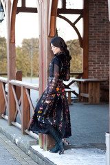 Beautiful woman with smile in dress near wooden handrail