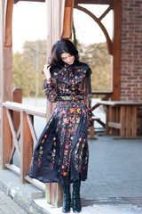 Beautiful woman with smile in dress near wooden handrail