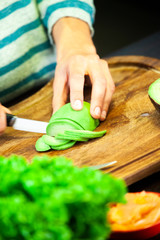 Woman cutting a ripe green avocado