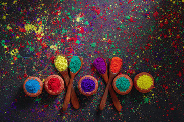 Indian Festival Holi , Colors in wooden spoon on dark background 