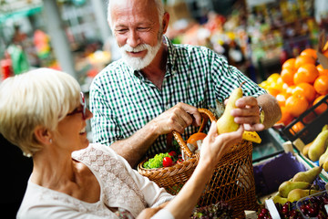 Portrait of beautiful elderly couple in market buing food