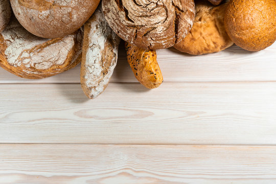 Different types of bread on a wooden background