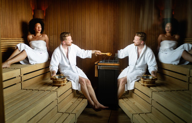 Beautiful young couple sitting together in a sauna