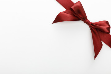 top view of satin burgundy decorative ribbon with bow isolated on white