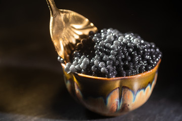 Black caviar and spoon close-up - obrazy, fototapety, plakaty