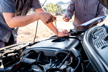 Repairman and insurance agent Checking engine order using modern tools