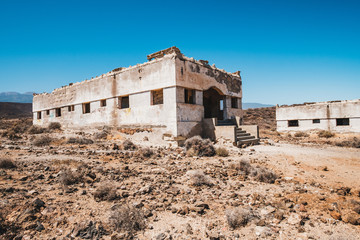 abandoned building ruins in ghost town in desert landscape