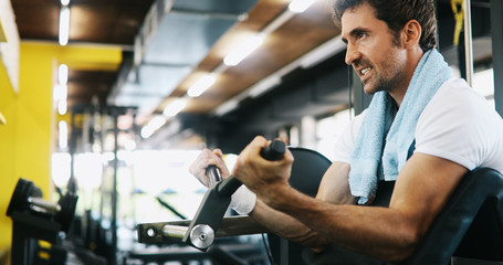 Healthy life and gym exercise concept. Fit man working out in sport fitness club