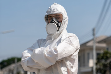 Woman wearing gloves with biohazard chemical protective suit and mask. She crossed her arms with...