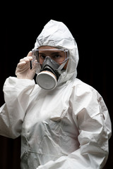 Woman wearing gloves with biohazard chemical protective suit and mask.