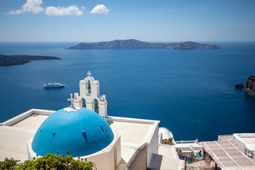 Fototapeta na wymiar Fantastic travel background. Famous travel and vacation destination in Santorini, Fira. Church and dome with beautiful sea view. Summer landscape and seascape.