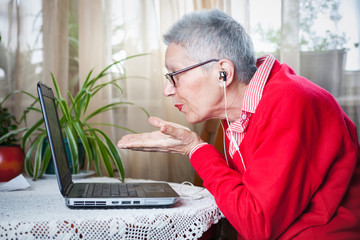 Old lady having a pleasant skype call on her laptop