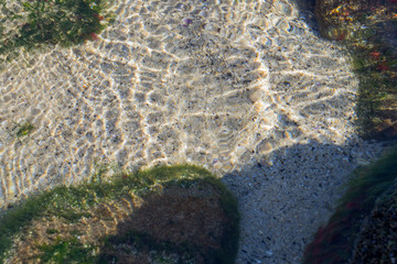 clear sea water and stones on a sunny day