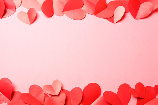 Cut Out Of Red Paper Hearts On Pink Background.