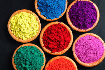 Indian Festival Holi , Colors in wooden bowl on dark background