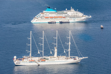 Beautiful sailboat and cruise ship, moored at the Santorini bay. 