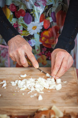 Man cutting slices of onion on a wooden board