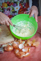 Preparations in a kitchen, hands mixing ingredients in a bowl