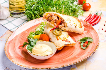 Closeup of kebab in a pancake with vegetables and sauce. Chicken fajita wrap sandwich