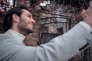 Happy young guy taking a photo of himself in autumn