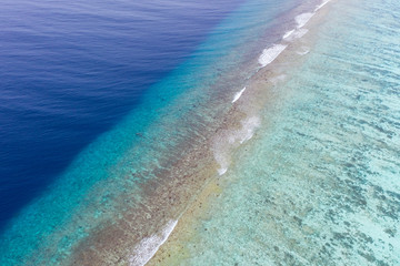 Aerial view of tropical coastline, shallow lagoon water small waves