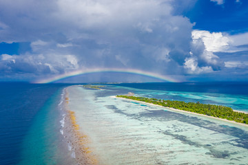 Fantastic aerial landscape in Maldives islands, stormy clouds with rainbow and amazing sea view