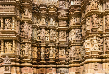 Fototapeta na wymiar Close up of artful carved walls of Kandariya Mahadeva Temple, Khajuraho Group of Monuments, India