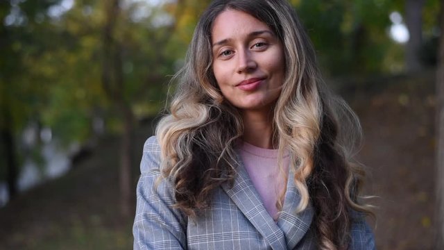 Caucasian woman turning head and smiling outdoors in a park