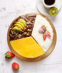 Homemade sweet cake with fruits, chocolate, apple, kiwi, strawberry, orange on white background with cup of coffee americano. Organic dessert sugarless, no fat. Healthy eating.