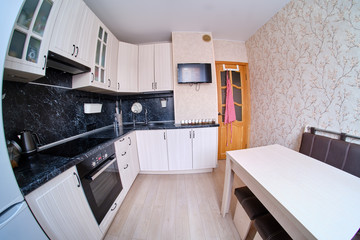 Fototapeta premium Modern black and white kitchen. High gloss kitchen with table and countertop (fisheye photo)