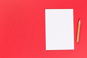Obraz na płótnie Canvas top view of blank open notebook on red background, office equipment, school supplies and education concept