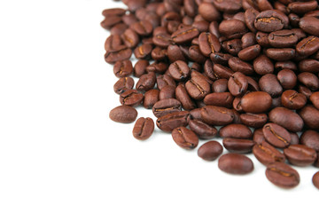Dark coffee beans placed on a white scene.