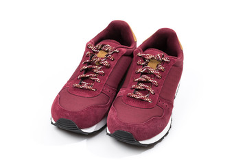 a pair of new burgundy, cherry sneakers or athletic shoes isolated on a white background.
