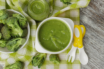 Fresh broccoli in the bowl, and portion of puree made from crushed, boiled broccoli