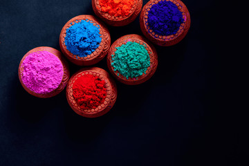 Indian Festival Holi , Colors in wooden bowl on dark background